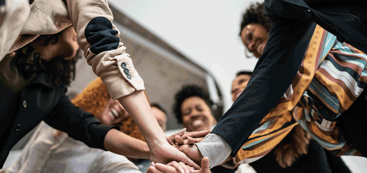 Um grupo de pessoas juntando as mãos