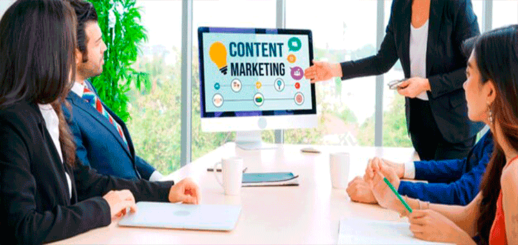 Pessoas sentadas a mesa vendo uma tela escrita "Content Marketing"