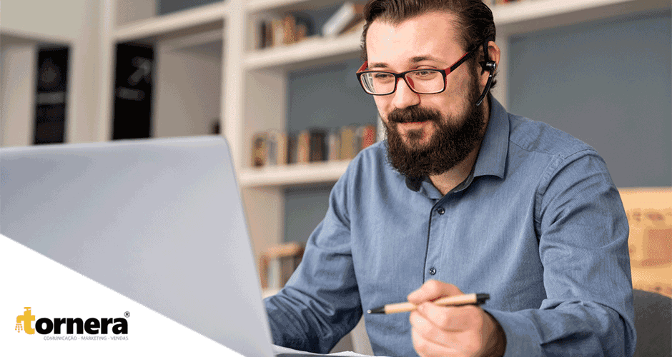 Um homem sentado à mesa usando um laptop