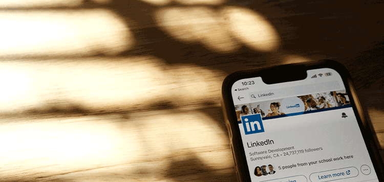 Um celular com LinkedIn aberto em cima de uma mesa de madeira