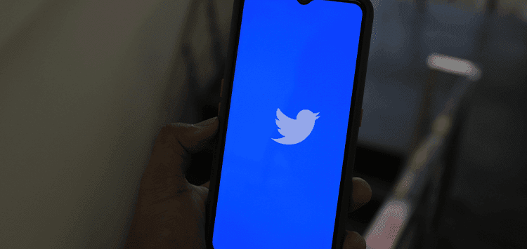 Uma pessoa segurando um telefone com o logotipo do Twitter