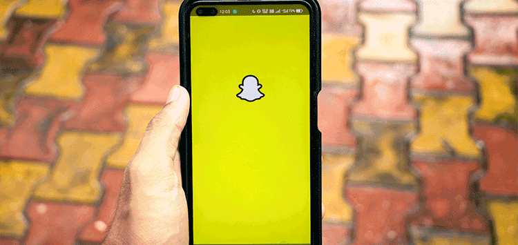 Uma pessoa segurando um telefone celular com um ícone de snap nele