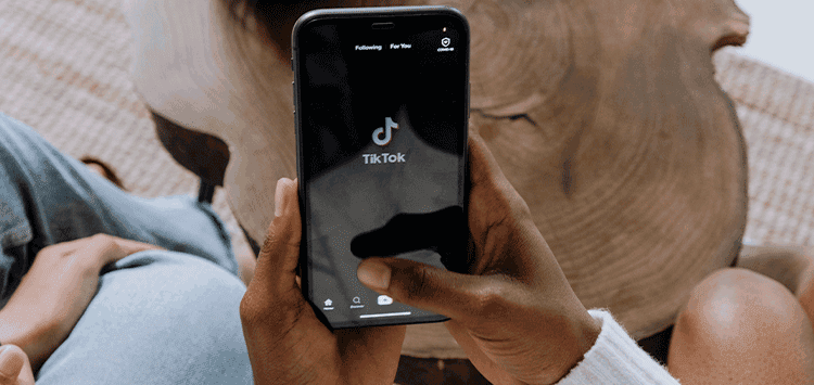 Uma pessoa segurando um celular na mão com TikTok