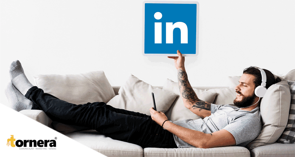 Um homem deitado em um sofá segurando uma placa do Linkedin